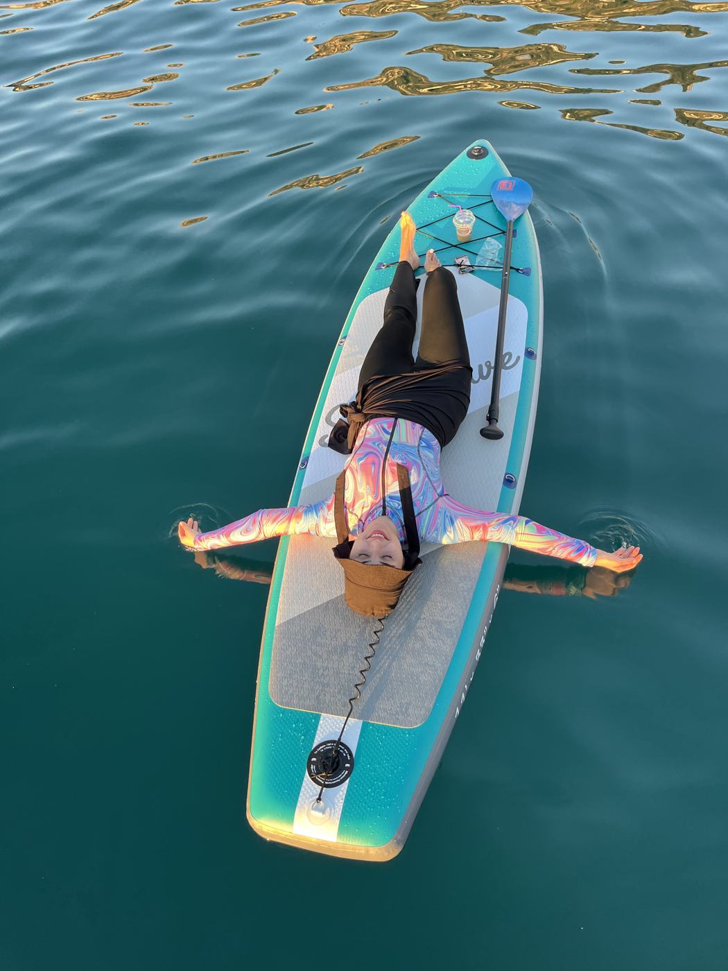 Top-down shot of a guest lying on a board in turquoise water