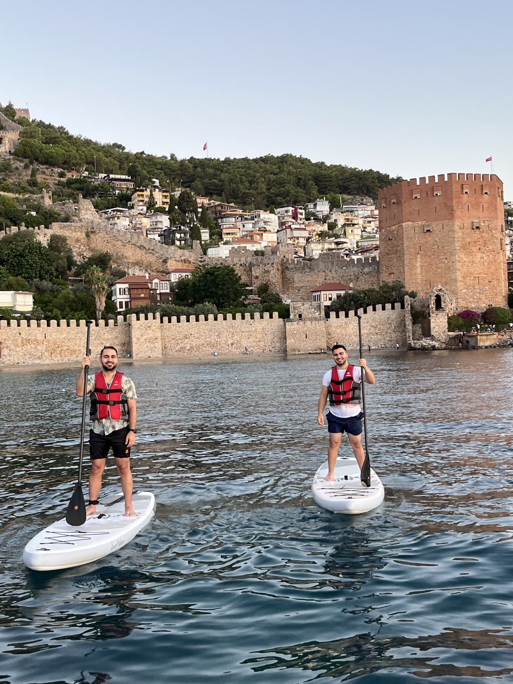 Two paddlers standing on boards by the Red Tower