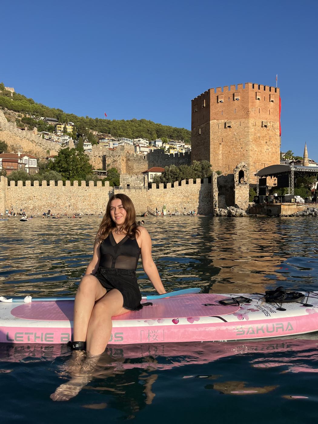 Guest on a paddle board in front of the Red Tower in golden morning light