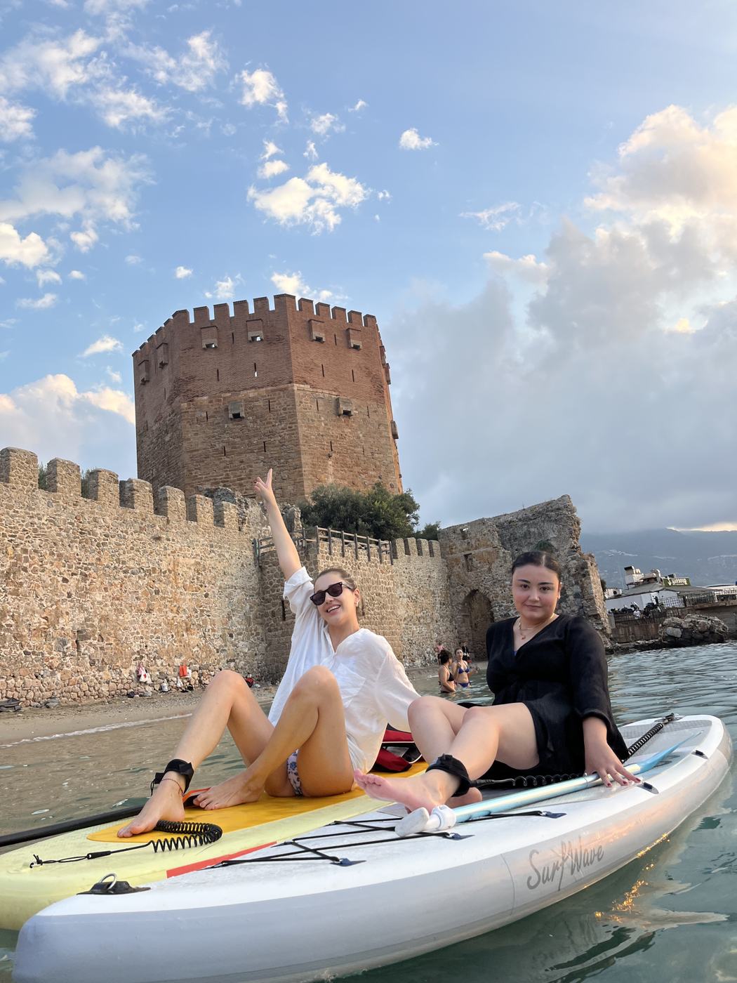 Two guests on a board in front of the Red Tower